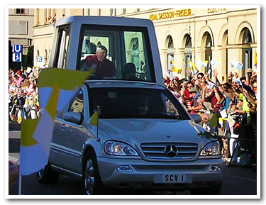 窓の開いたパパモビールに乗ってパレードする教皇